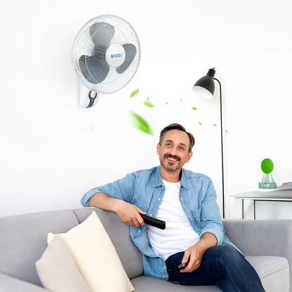 A man sitting on a sofa enjoying the breeze from a 16-inch Wall Fan, demonstrating the ideal cooling solution for home comfort.
