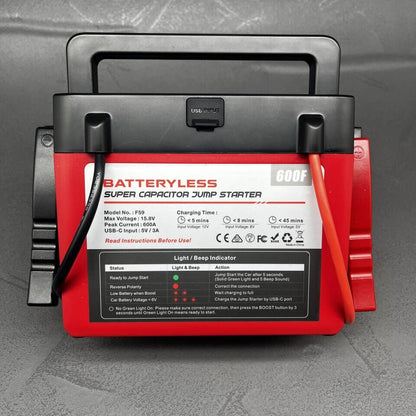 Red and black batteryless super capacitor jump starter on a gray textured background